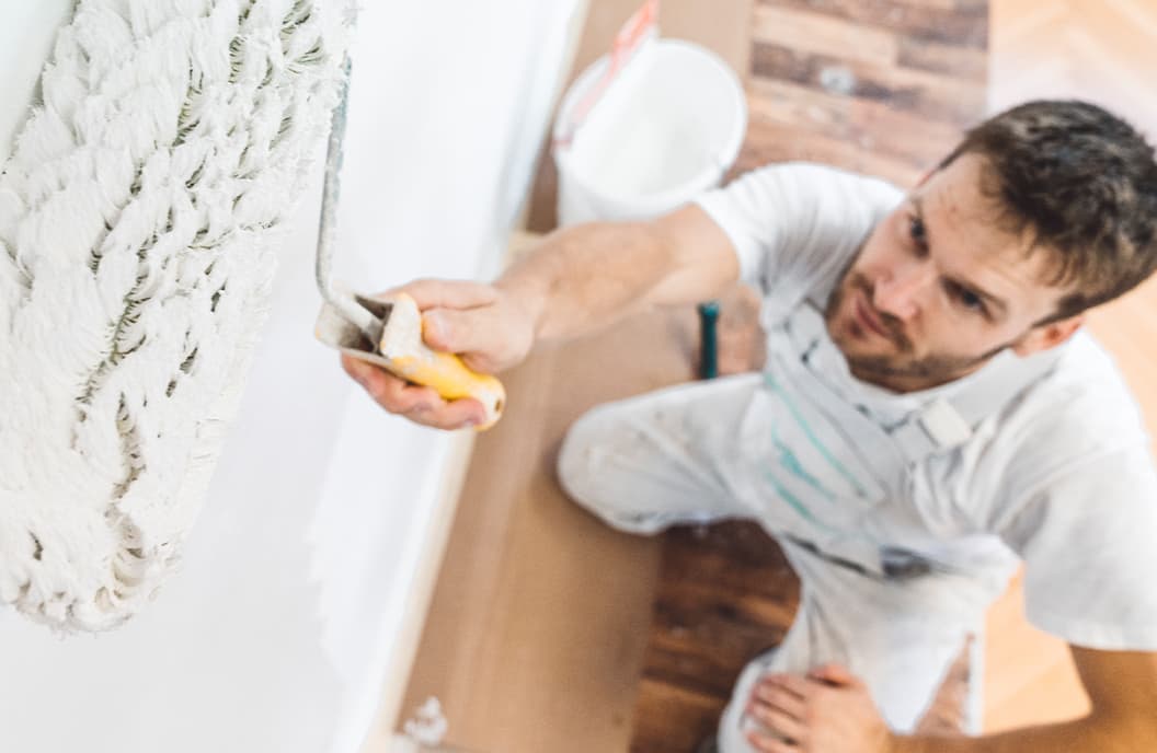 Decorator applying paint to a wall