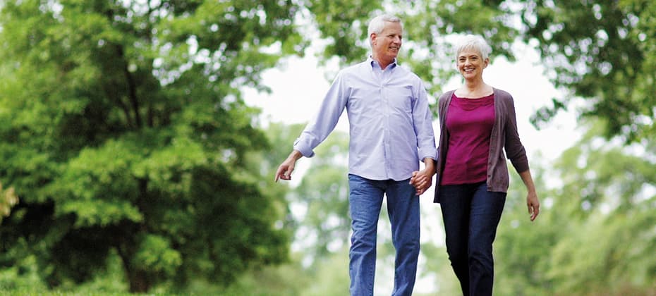 Elderly couple walking in public park